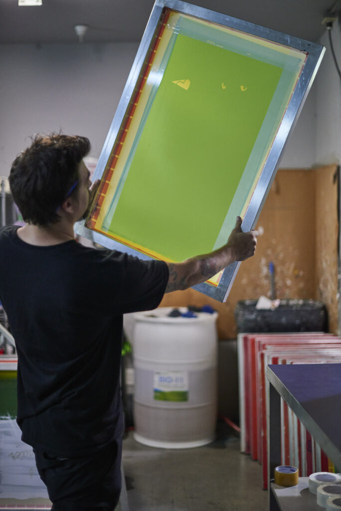 employee checking a screen at a screen printing shop